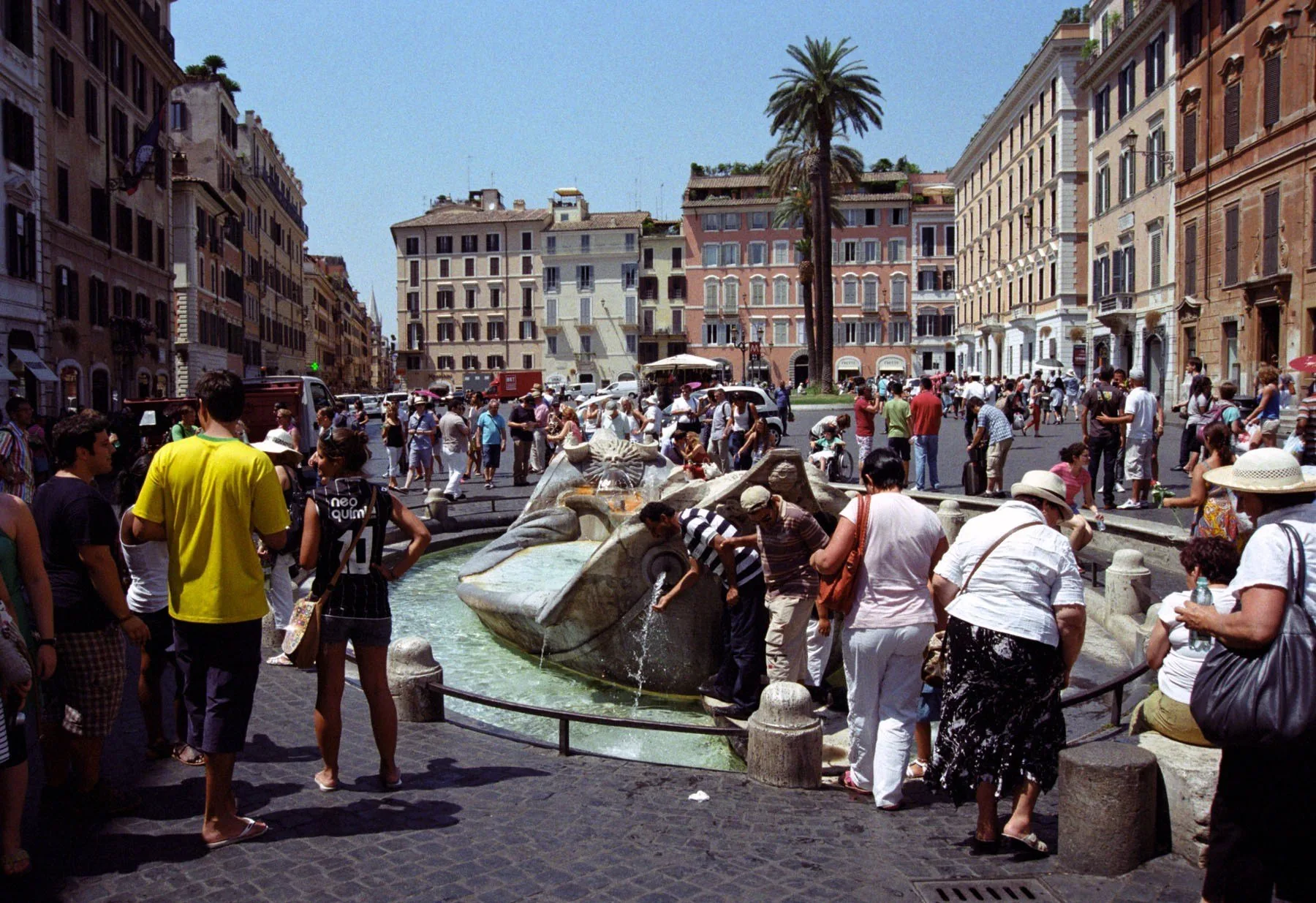 Turisti alla Fontana della Barcaccia a Roma in una giornata calda