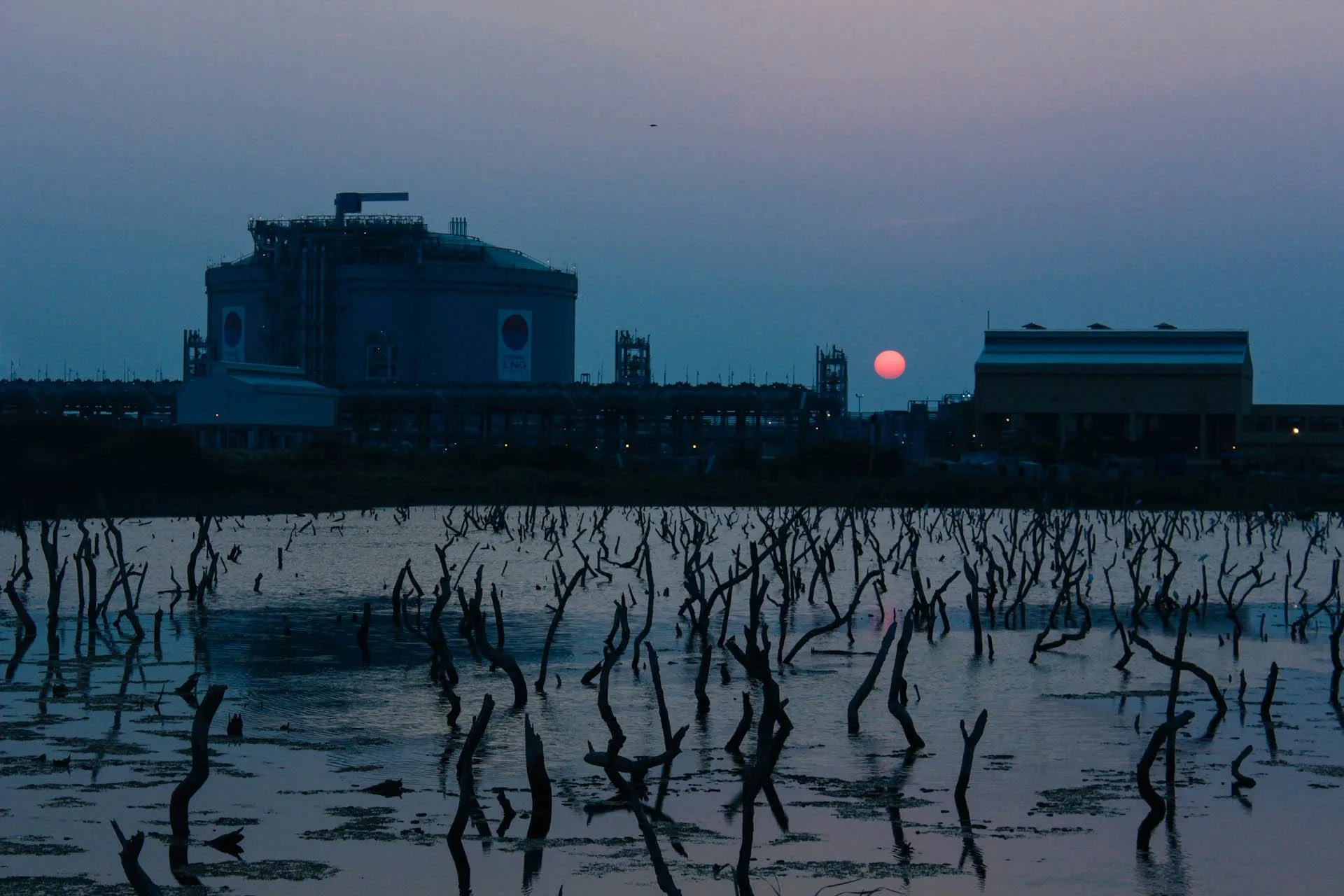 Terminale per gas naturale liquefatto con serbatoio e impianti al tramonto