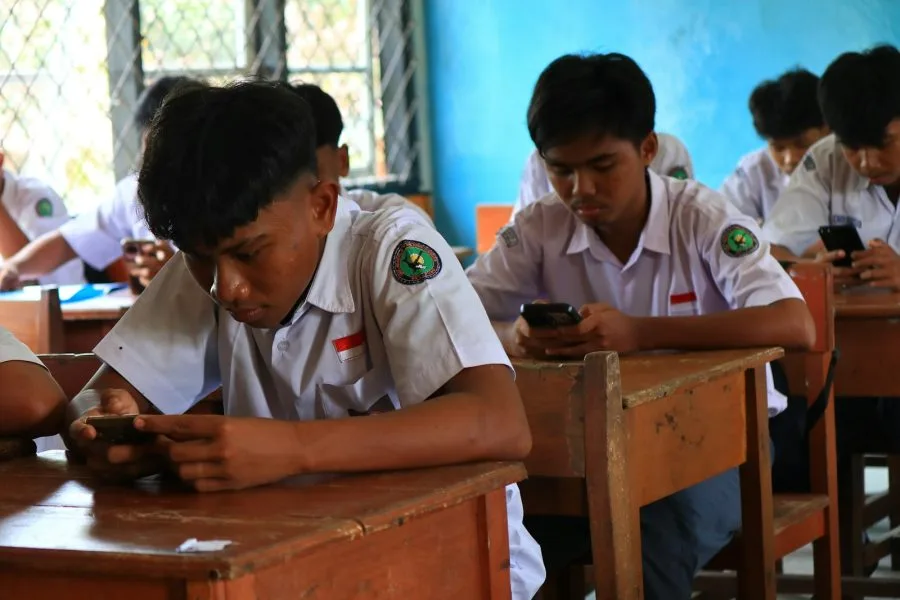 Studenti seduti in classe mentre usano lo smartphone