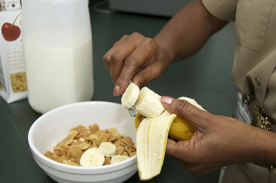 Preparazione di una colazione con cereali, latte e banana in un contesto di educazione nutrizionale