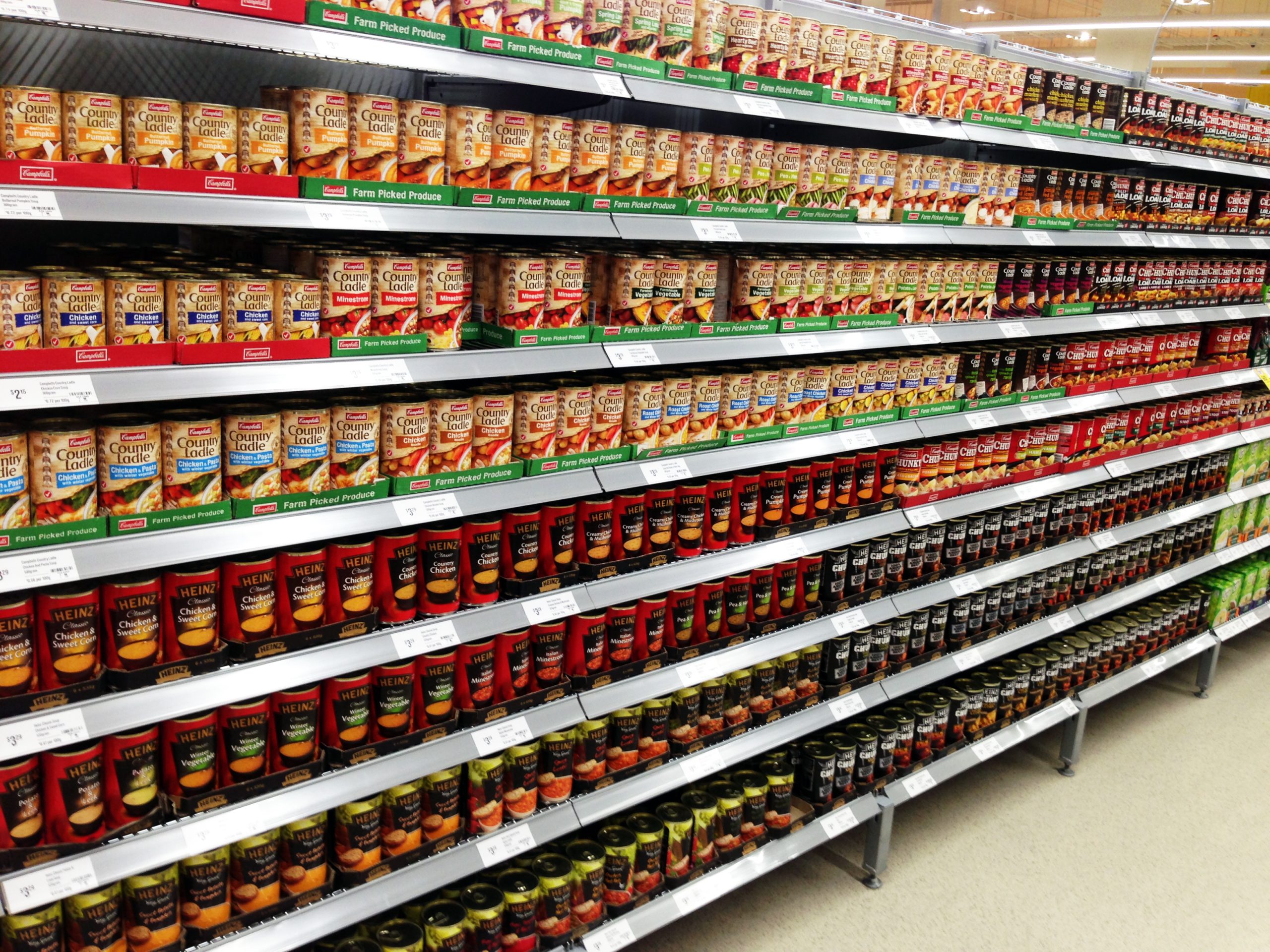 Scaffali di supermercato con prodotti confezionati e cartellini prezzo