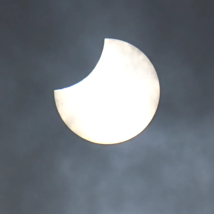 Eclissi solare parziale con la Luna che copre una porzione del Sole