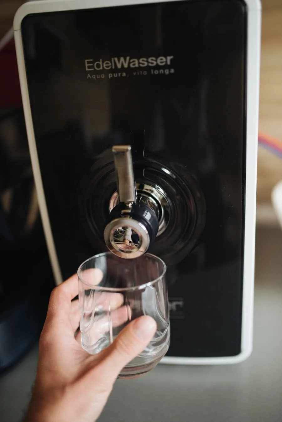 Bicchiere sotto un moderno dispenser di acqua filtrata