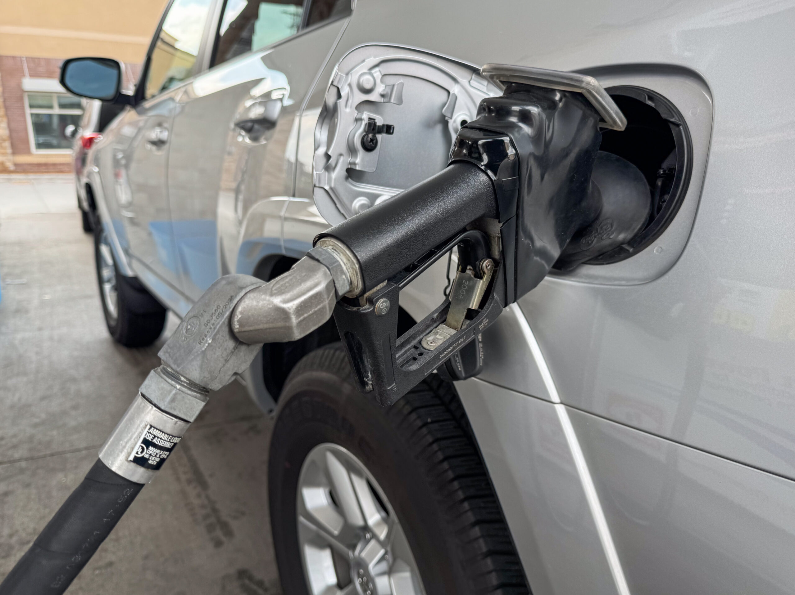 Rifornimento carburante con pistola della pompa inserita in un auto