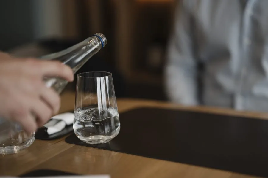 Bicchiere riempito con acqua al tavolo di un ristorante