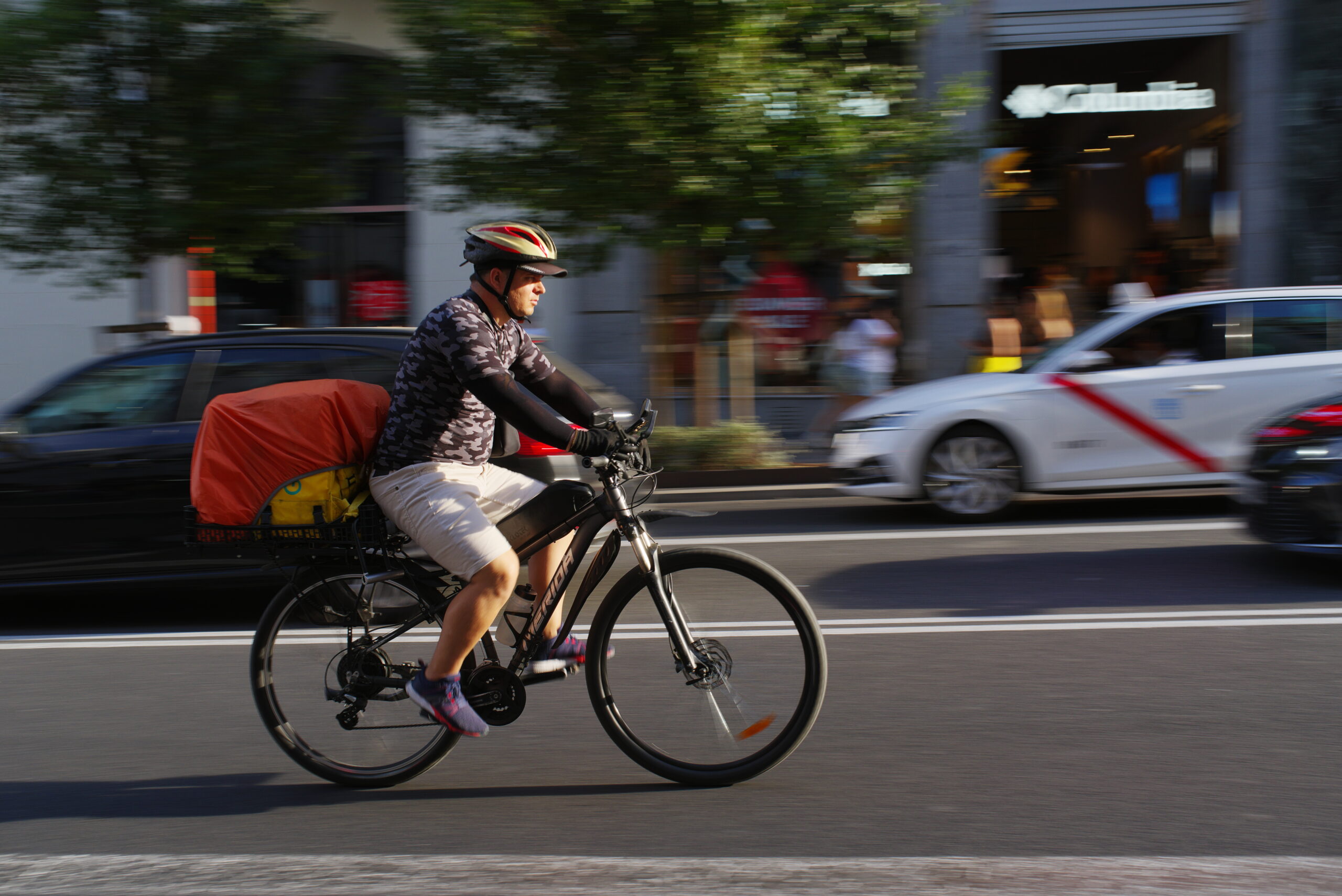Rider Glovo in bicicletta in una strada urbana