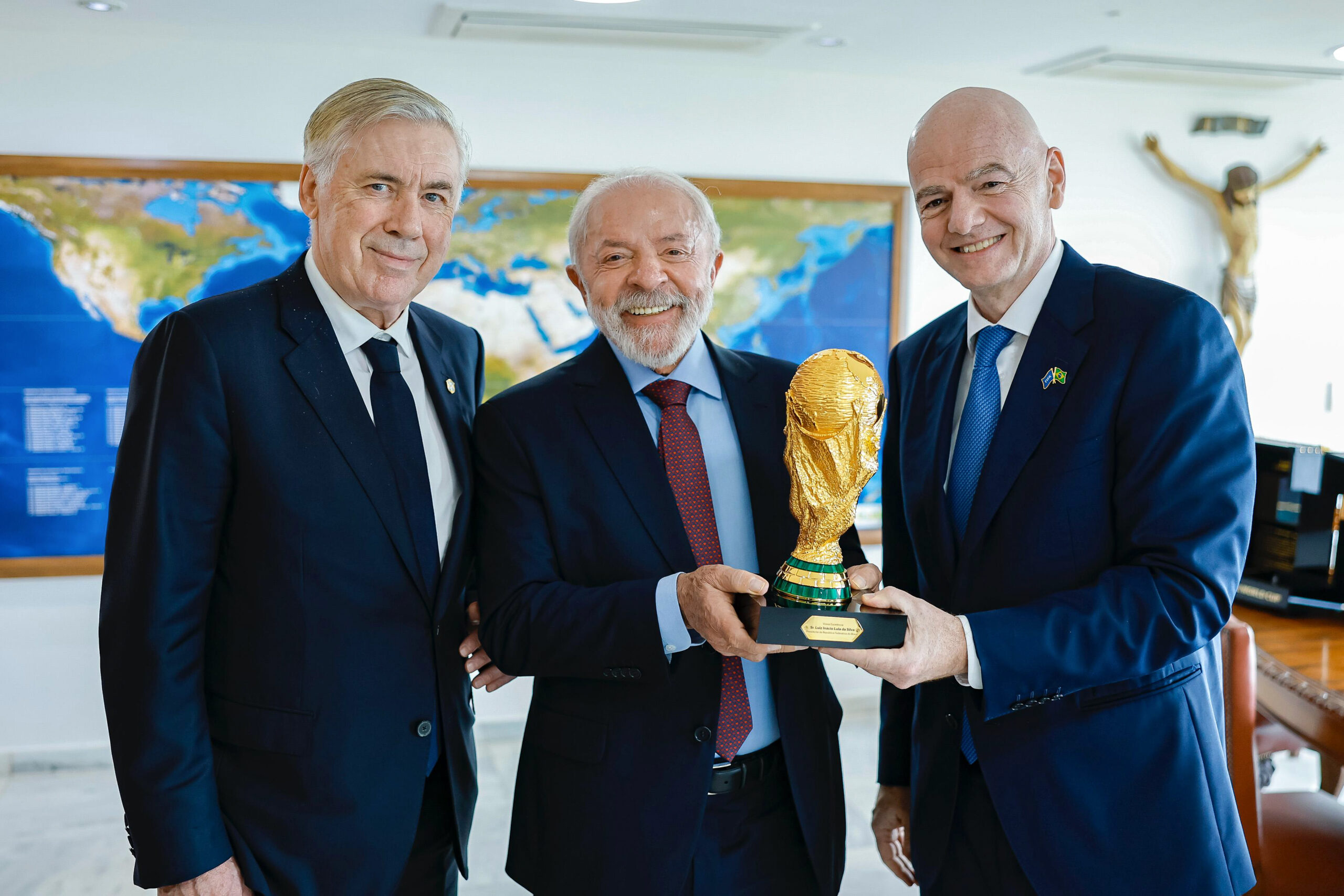 Gianni Infantino in abito scuro durante un incontro istituzionale con una coppa del mondo