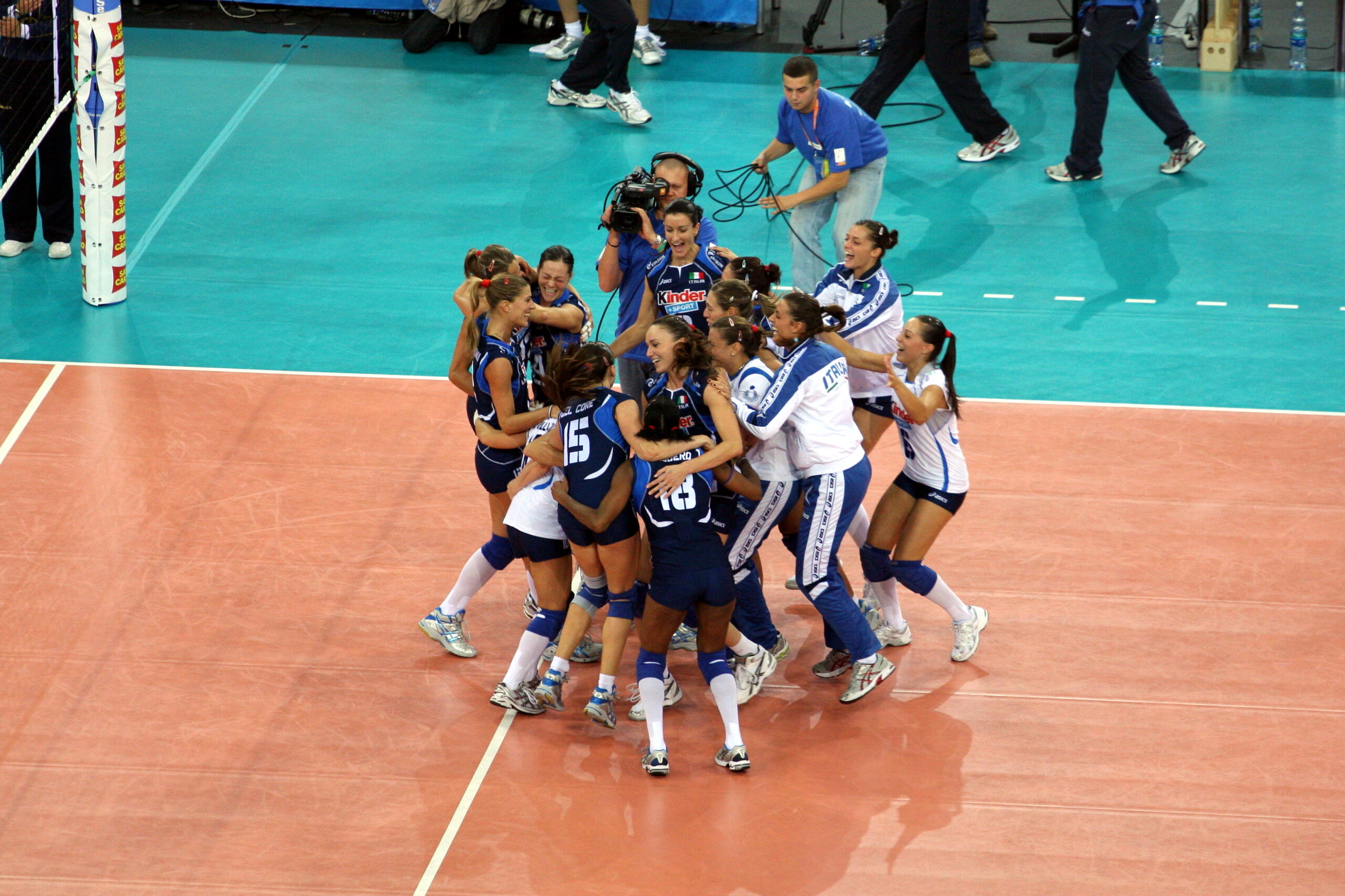 La nazionale femminile italiana di volley festeggia su un campo da pallavolo