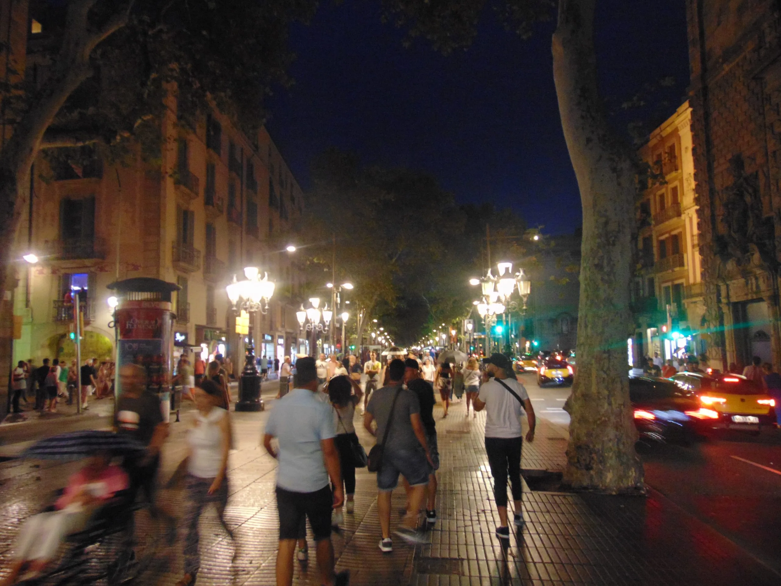La Rambla a Barcellona di notte con pedoni e traffico urbano