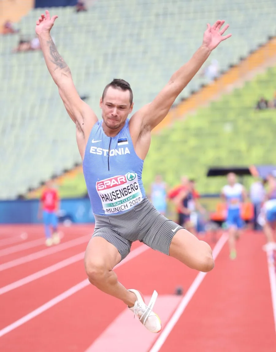 Atleta in fase di salto in lungo su pista di atletica