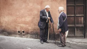 Due persone anziane conversano in strada
