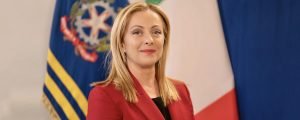 Giorgia Meloni davanti alle bandiere italiana ed europea