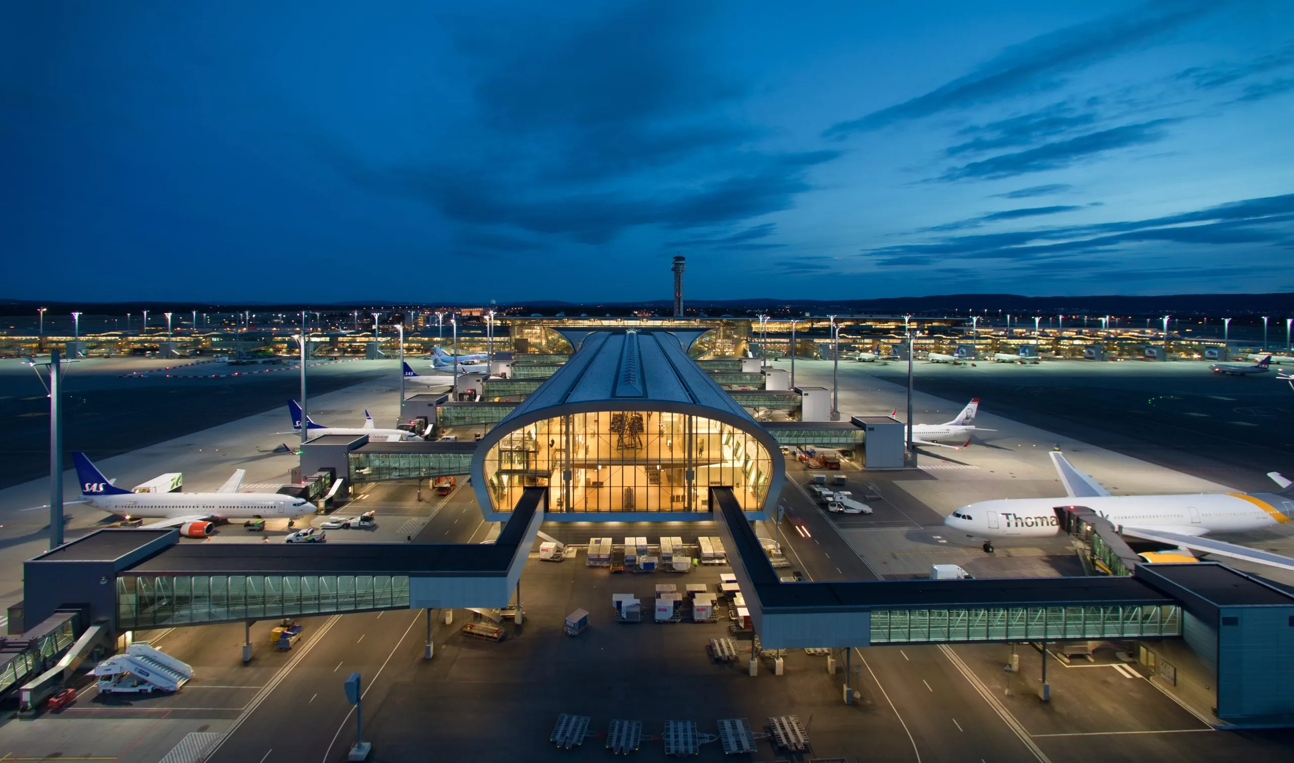 Aeroporto di Oslo Gardermoen illuminato con terminal, piste e aerei