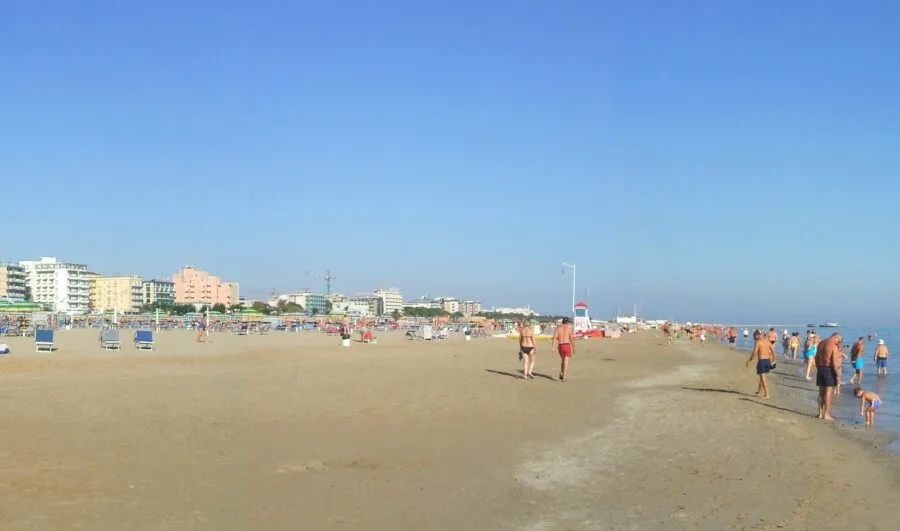 Spiaggia di Rimini con turisti e stabilimenti balneari in estate