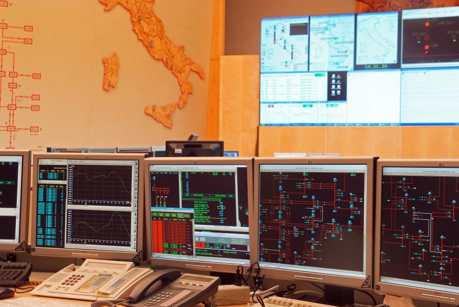 Sala di controllo del Centro Nazionale di Controllo di Terna con monitor e mappe della rete elettrica
