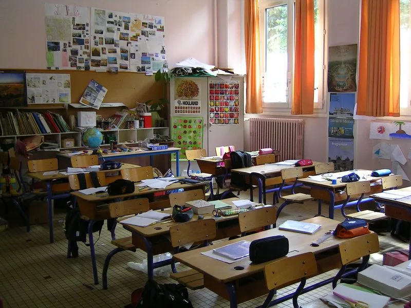 Aula scolastica con banchi, quaderni e astucci prima delle lezioni