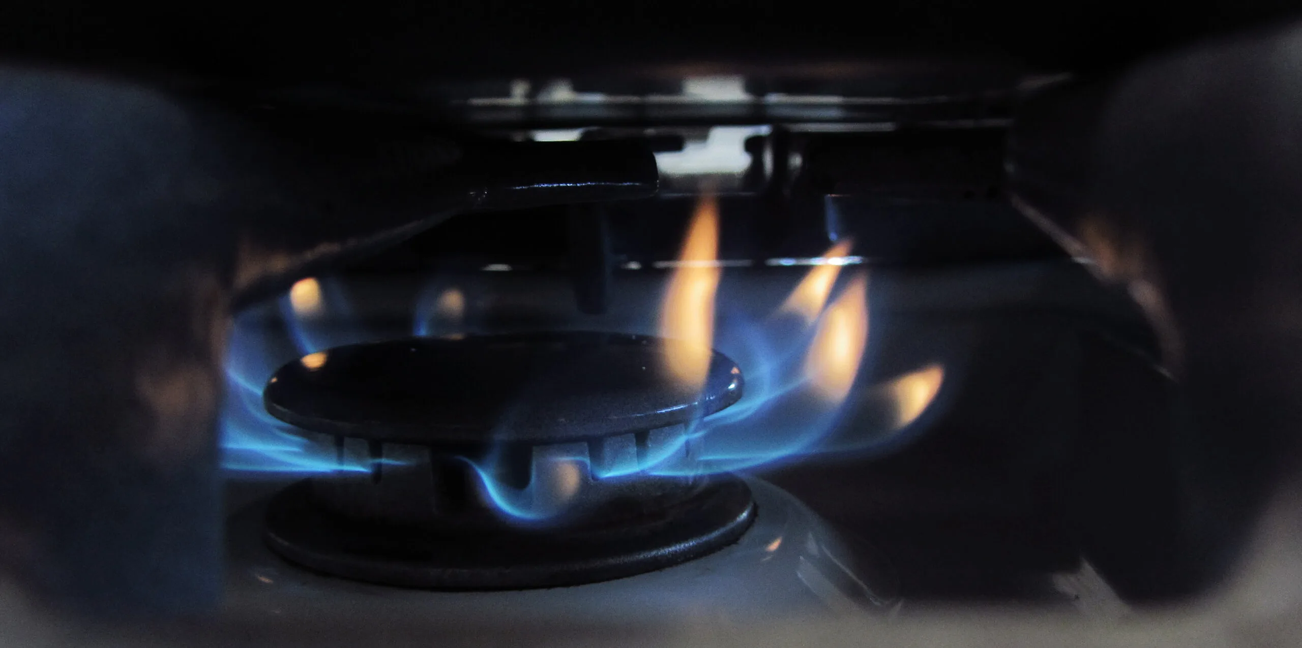 Fiamma blu di un fornello a gas acceso in cucina