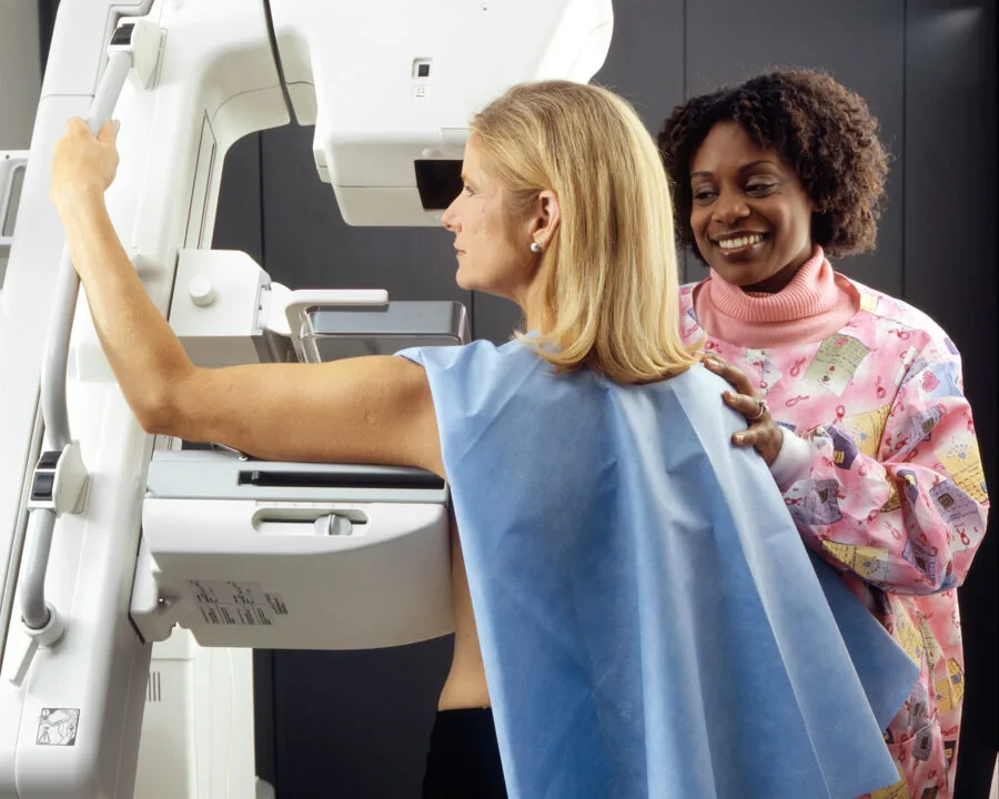 Tecnica sanitaria assiste una donna durante una mammografia di screening