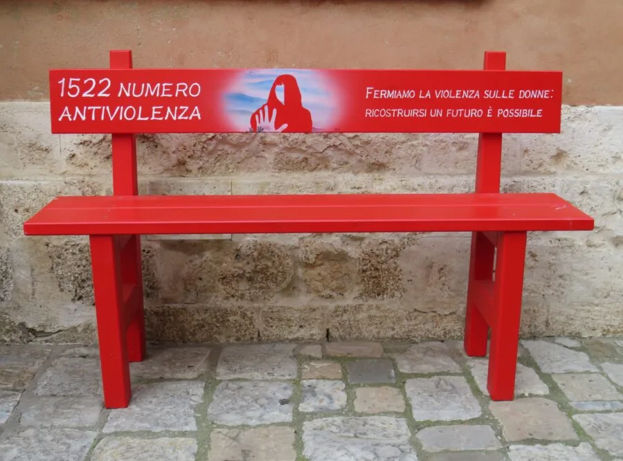Panchina rossa con numero antiviolenza 1522 e scritta contro la violenza sulle donne