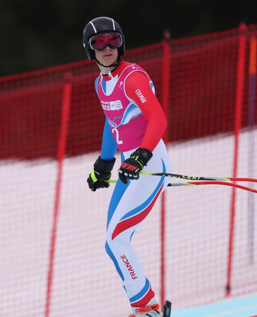 Sciatore in superG con reti di sicurezza rosse sul bordo pista
