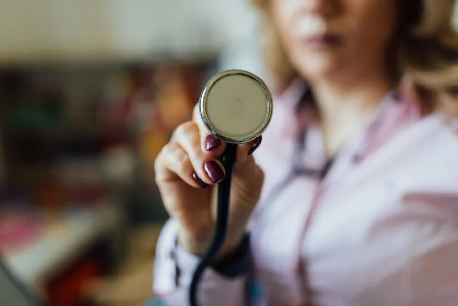 Stetoscopio tenuto da una dottoressa in ambiente clinico