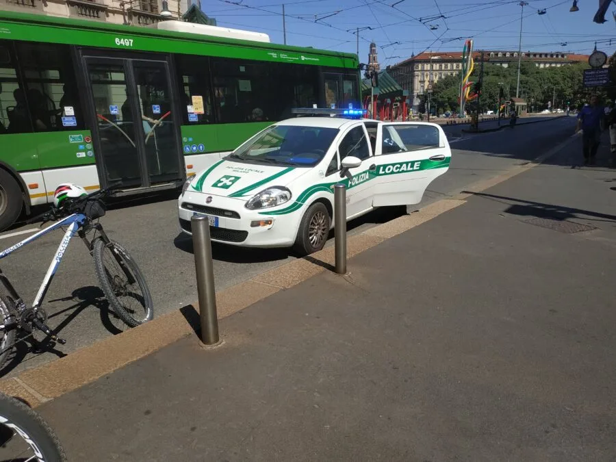 Auto della Polizia locale di Milano accanto a un autobus in strada