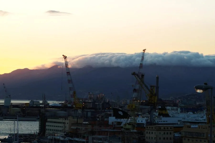 Banchi di nubi scendono dai monti verso il porto di Genova in una fotografia del 2014