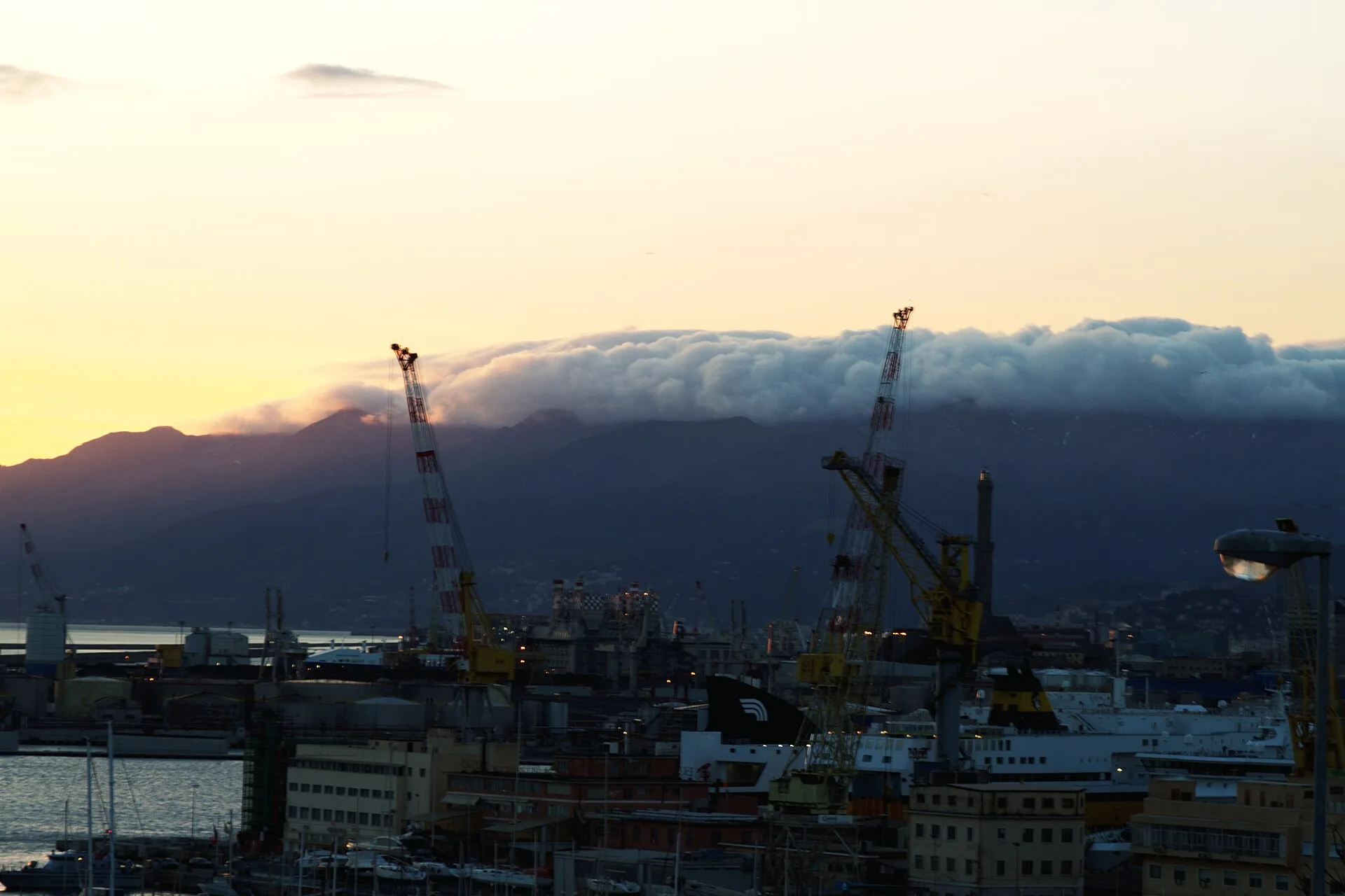 Banchi di nubi scendono dai monti verso il porto di Genova in una fotografia del 2014