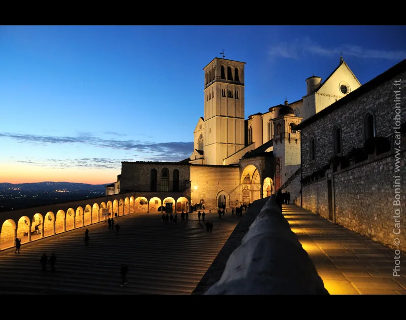 Basilica di San Francesco e piazza inferiore illuminate al tramonto ad Assisi, fotografia d’archivio del 2009