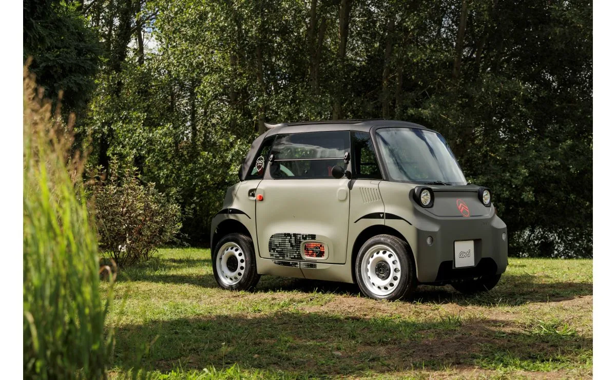 Citroën Ami OUTDOOR verde Khaki con porte chiuse e cerchi bianchi, fotografata su un prato