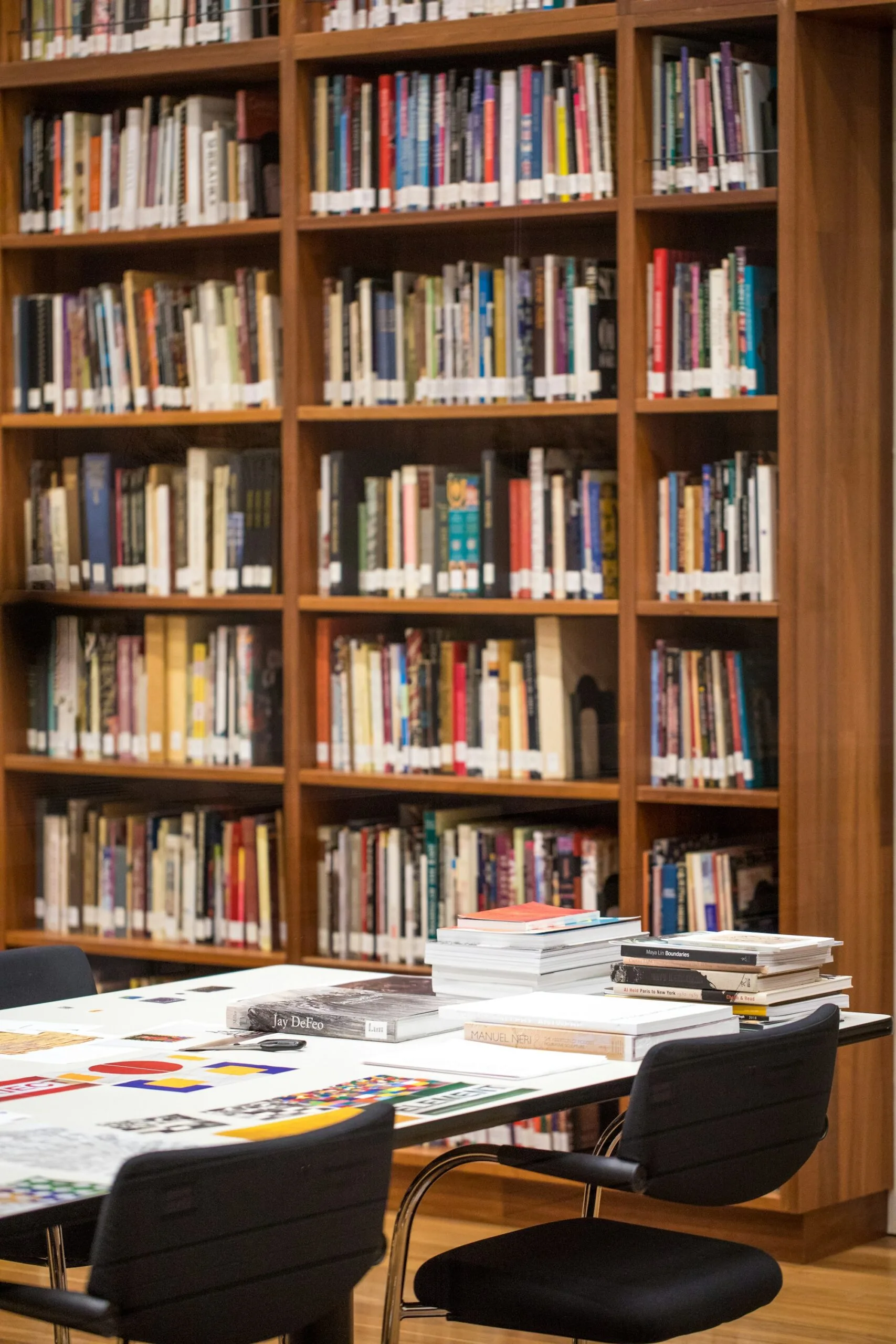 Scaffali di libri e tavolo per la consultazione in una biblioteca