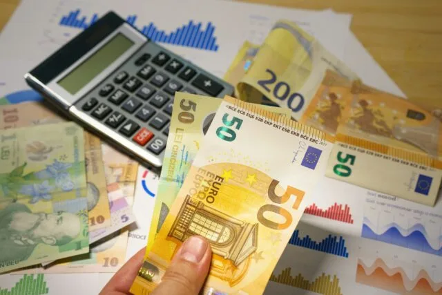 Calcolatrice e banconote per i conti del risparmio