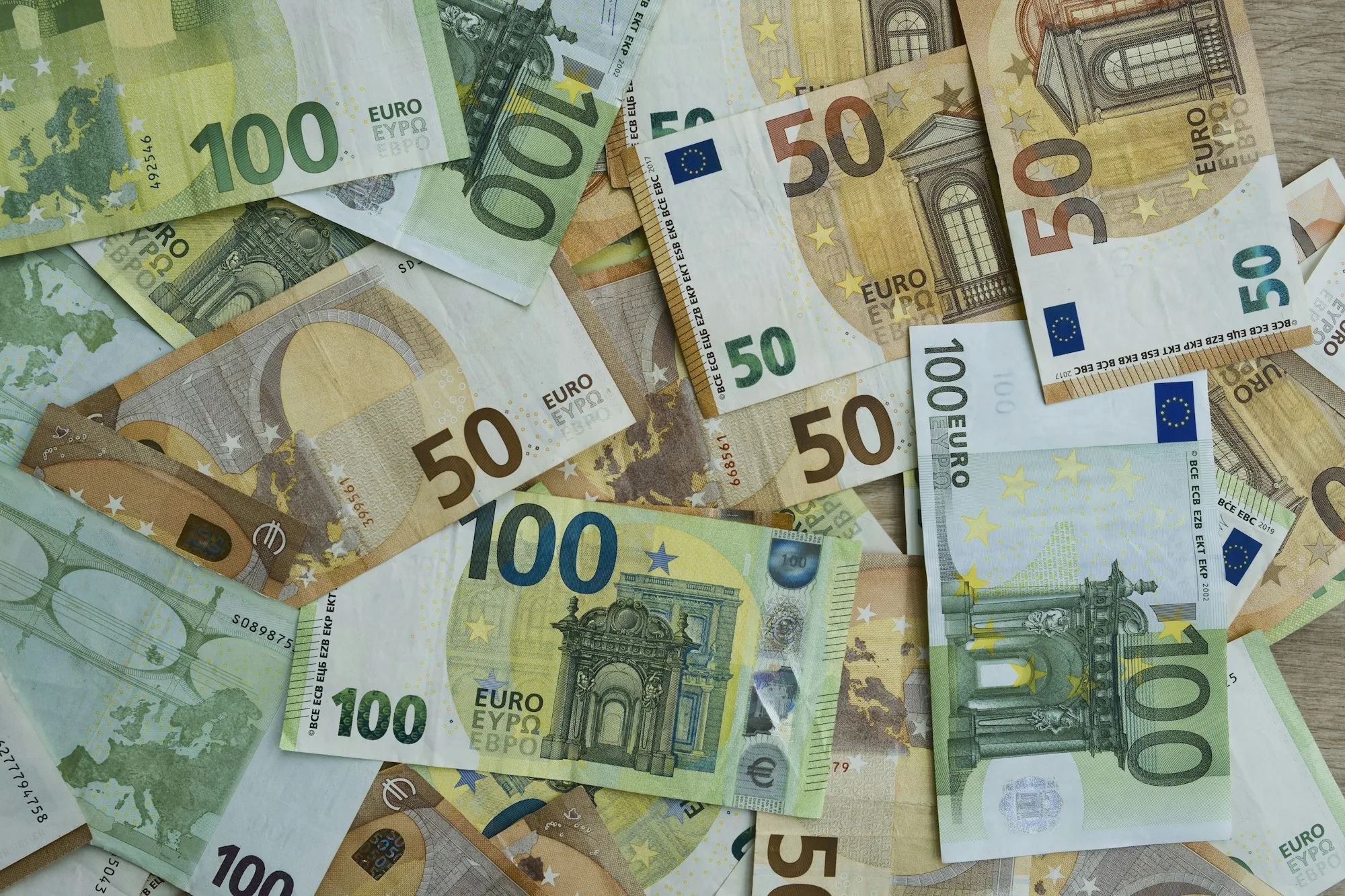 Banconote euro da 50 e 100 su un piano di legno
