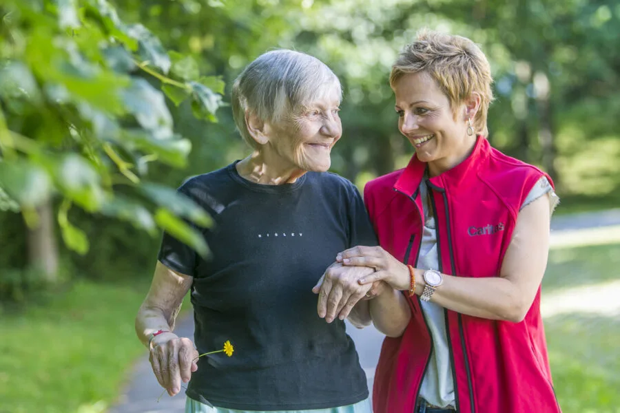 Caregiver assiste una persona anziana durante una passeggiata