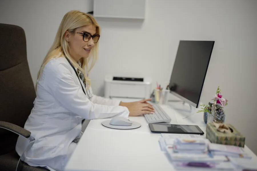 Medico al computer in uno studio, contesto dei dati sanitari digitali