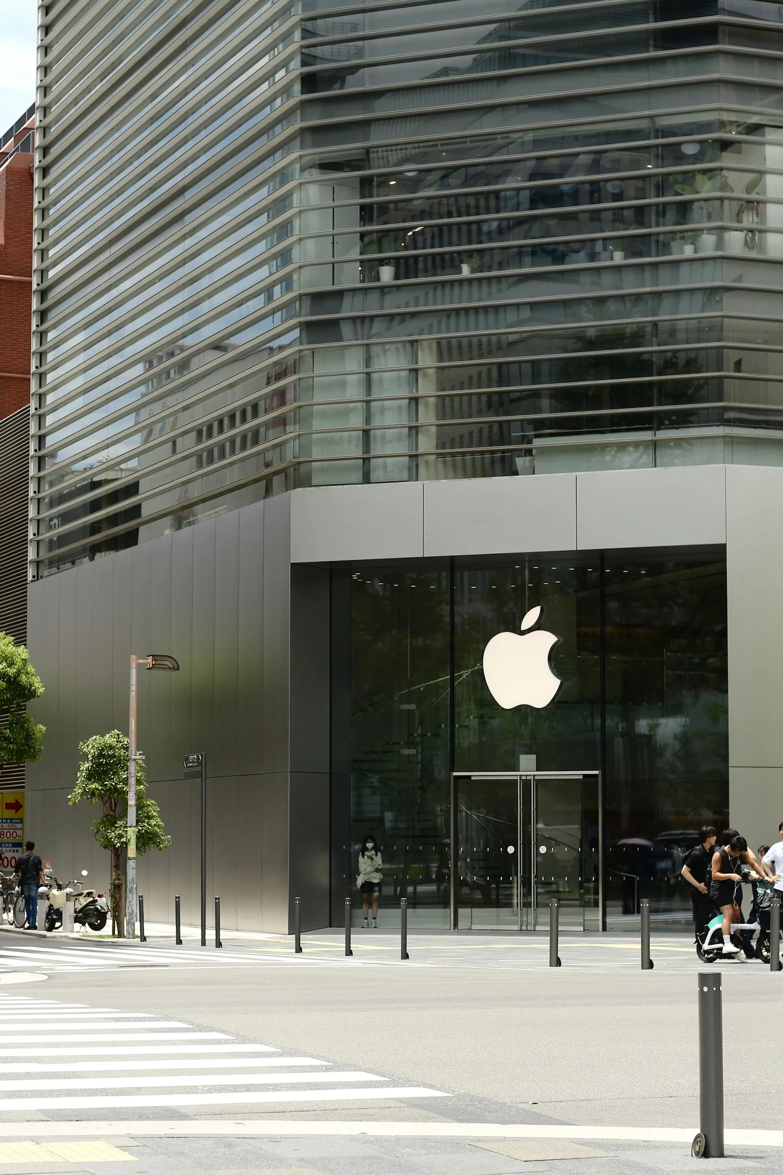 Facciata in vetro di un negozio Apple con logo e ingresso sulla strada