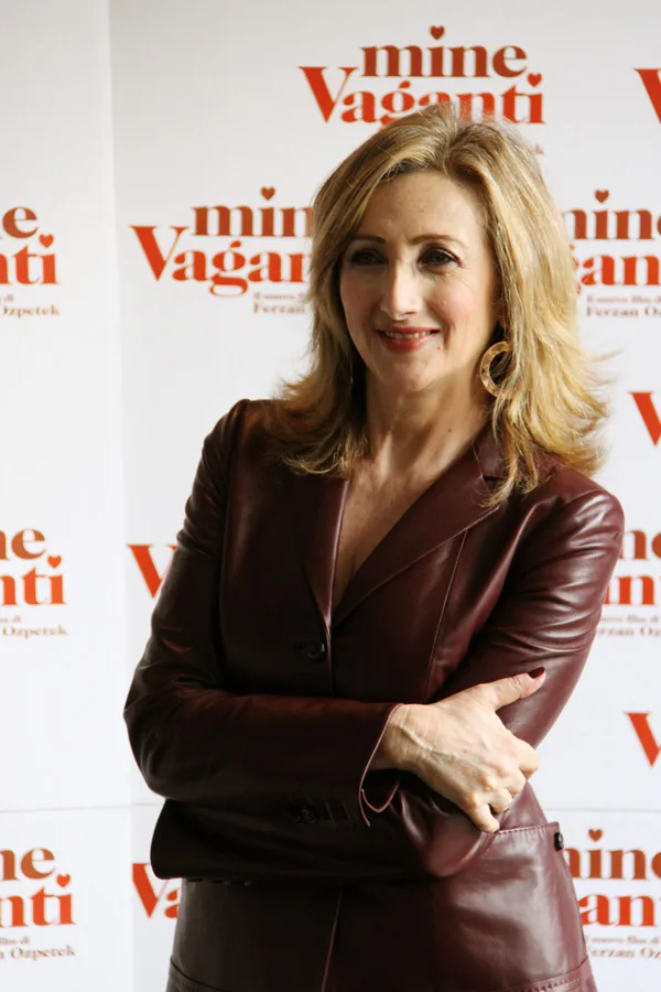 Lunetta Savino in posa davanti a uno sfondo promozionale di Mine vaganti, foto d’archivio del 2010