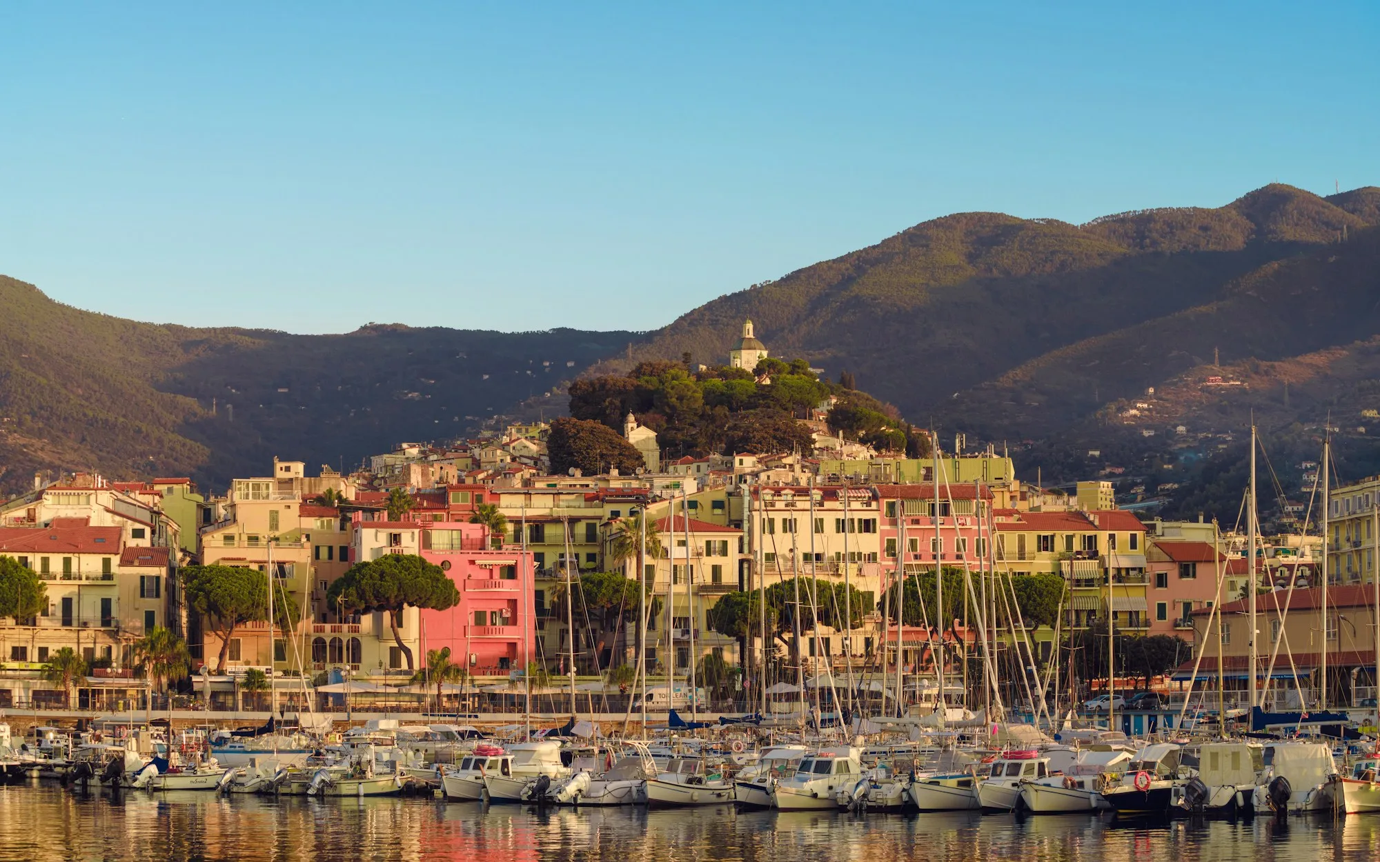 Imbarcazioni ormeggiate davanti agli edifici e alle colline di Sanremo