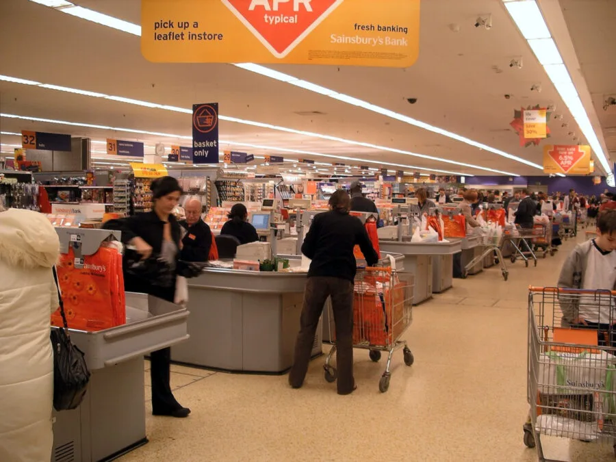 Casse di un supermercato con clienti e carrelli della spesa