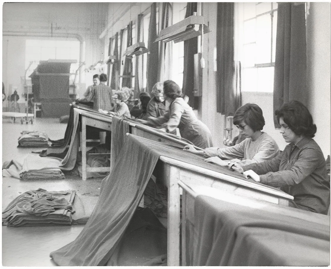 Lavoratrici in un reparto tessile di Prato mentre controllano il tessuto, fotografia del 1964