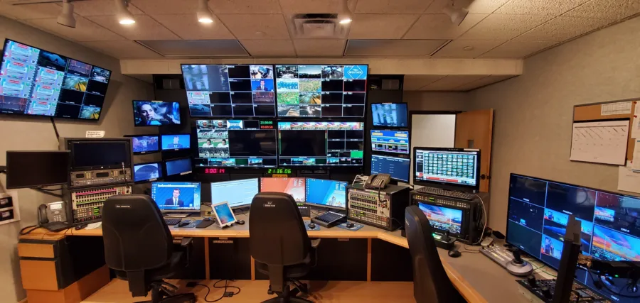 Una sala regia televisiva con monitor e postazioni di controllo per la diretta