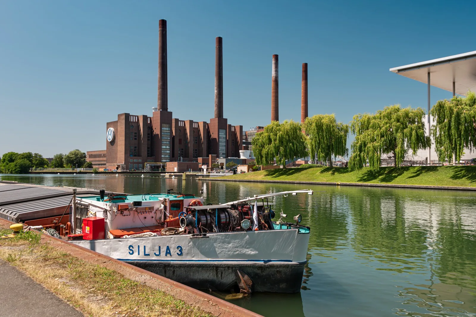 Edificio Volkswagen a Wolfsburg con quattro ciminiere visto dal canale