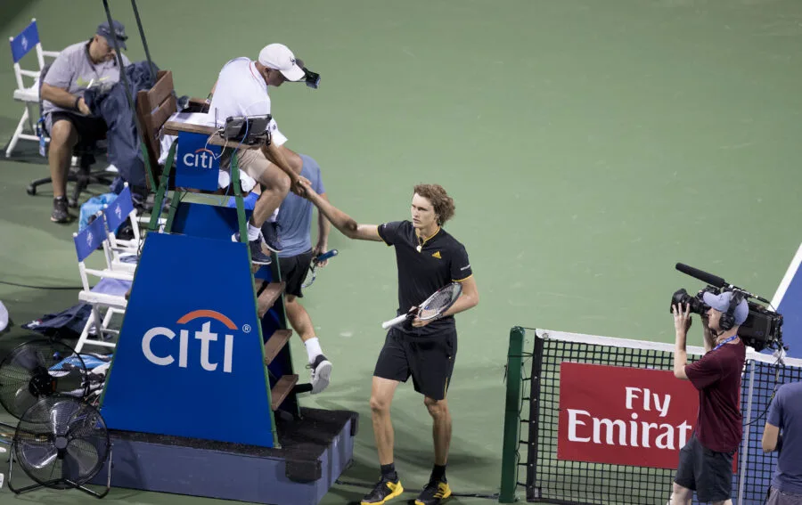 Alexander Zverev stringe la mano al giudice di sedia su un campo da tennis