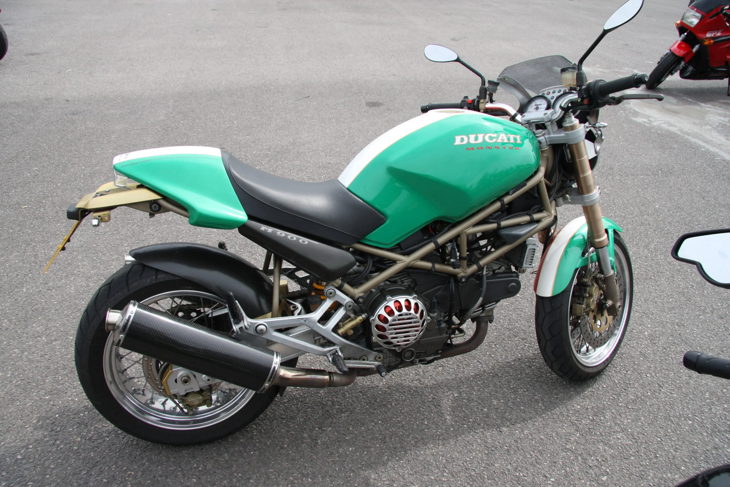 Ducati Monster verde e bianca di una generazione precedente, fotografata di tre quarti dal lato destro