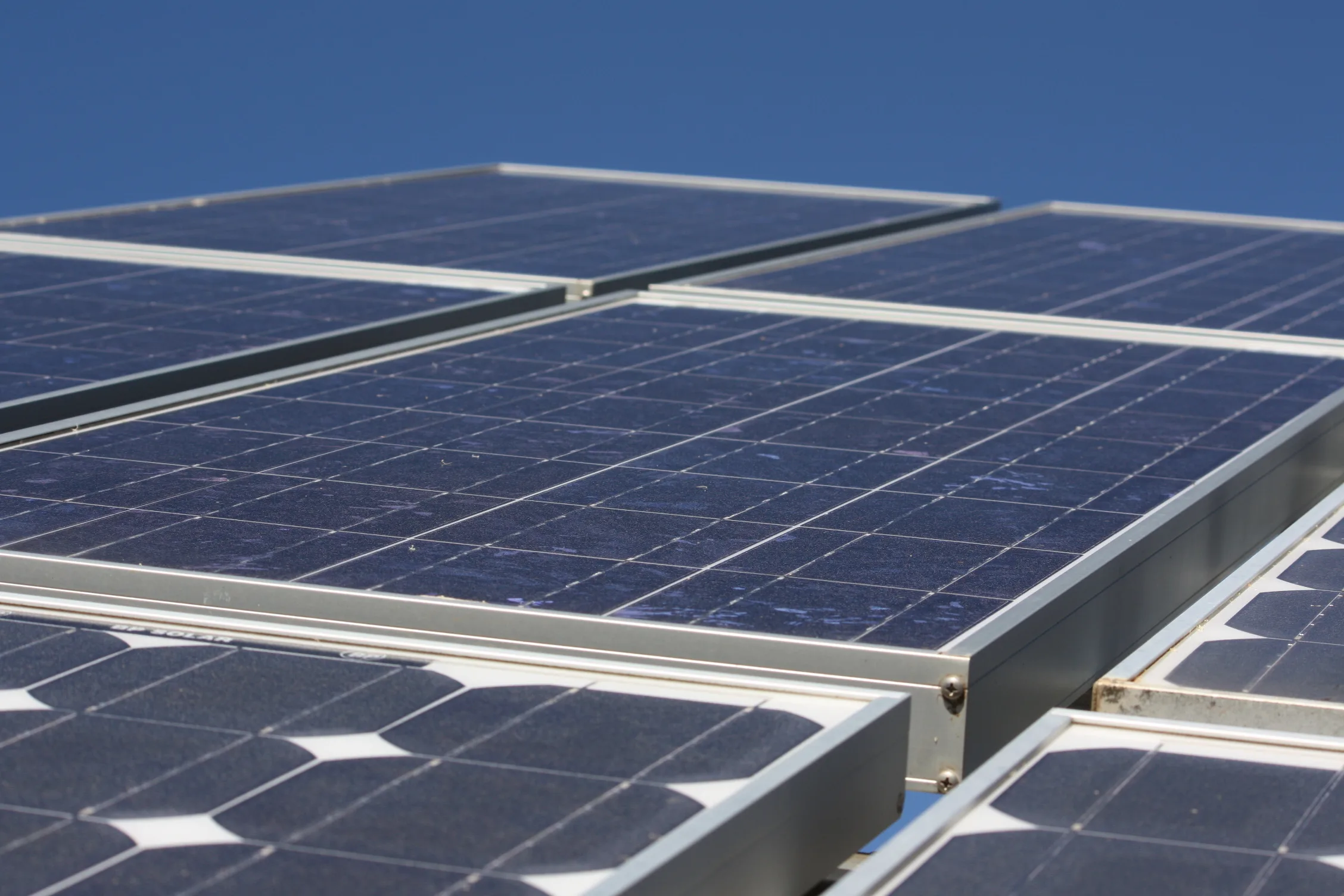 Moduli fotovoltaici con celle blu e cornici metalliche sotto il cielo sereno
