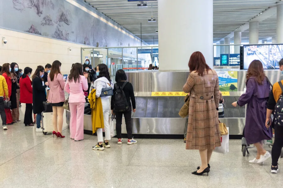 Viaggiatori in attesa dei bagagli al nastro in aeroporto